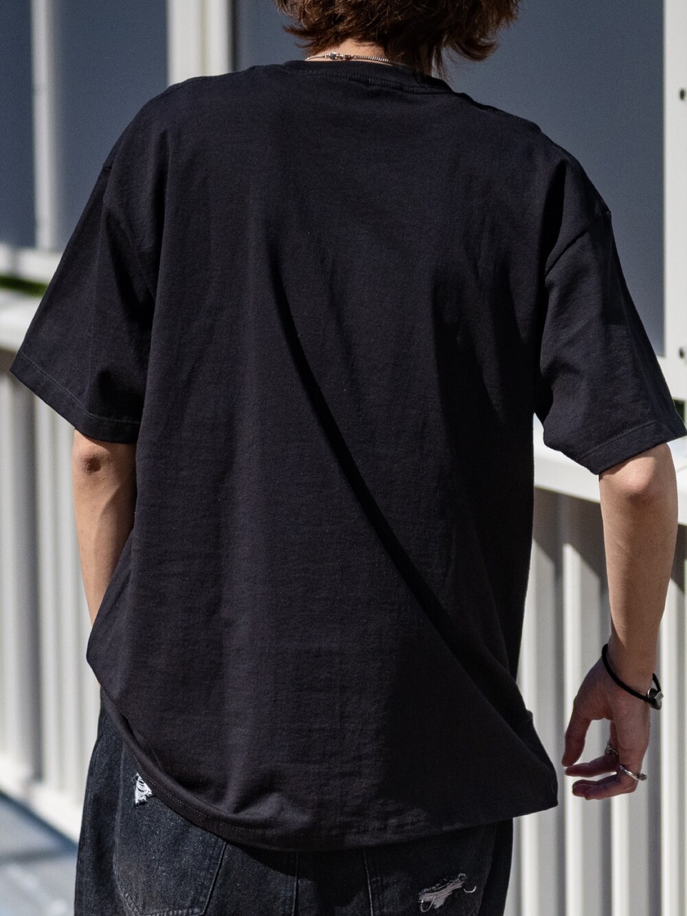 ブラック系のTシャツ/カットソー、ブラック系のデニムパンツを着用したメンズの春コーディネートの4枚目の写真