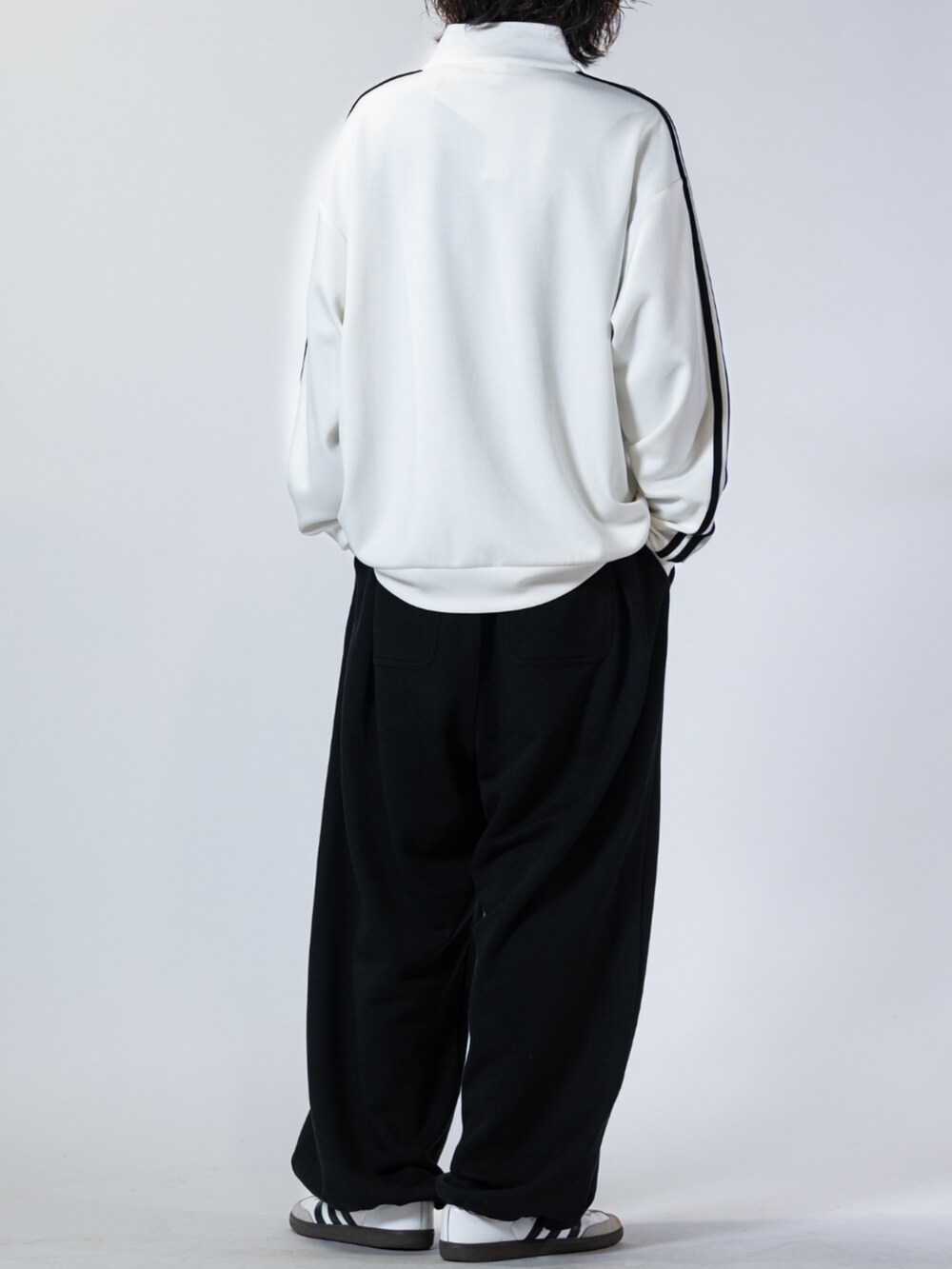 ホワイト系のスニーカー、ブラック系のスウェットパンツ、ホワイト系のスウェットを着用したメンズの春コーディネートの3枚目の写真