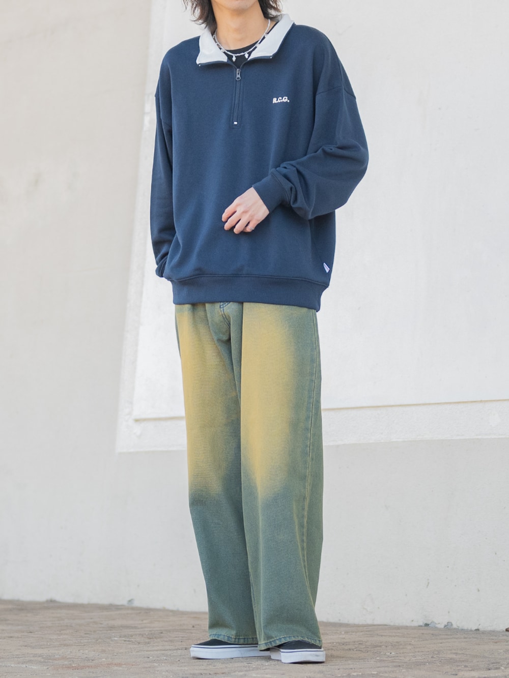 ブラック系のスニーカー、グリーン系のデニムパンツ、ブルー系のスウェットを着用したメンズの冬コーディネートの3枚目の写真