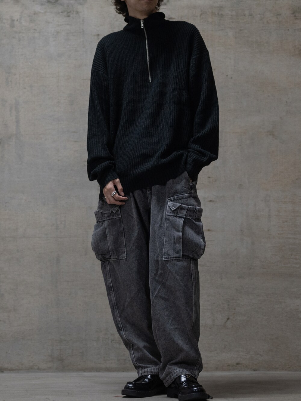 ブルー系のデニムパンツ、ブラック系のニット/セーターを着用したメンズの秋コーディネートの2枚目の写真