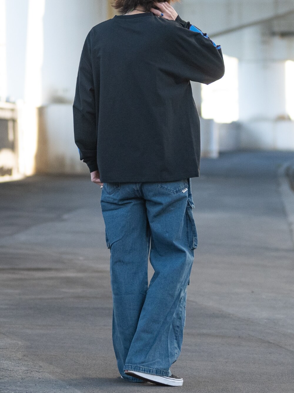 ブルー系のデニムパンツ、ブラック系のスニーカー、ブラック系のTシャツ/カットソーを着用したメンズの冬コーディネートの3枚目の写真
