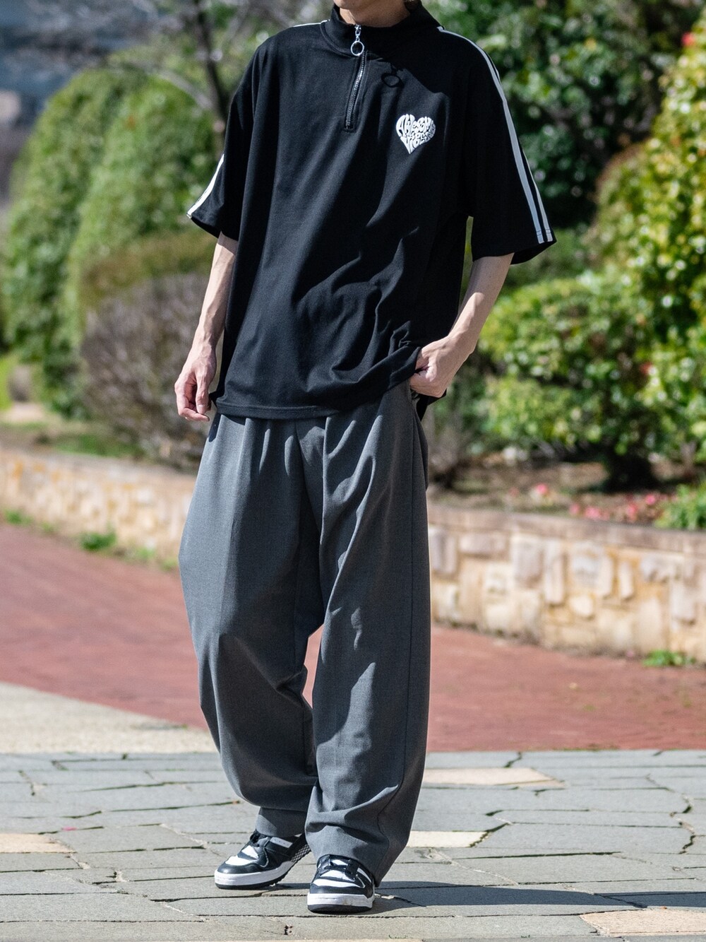 グレー系のスラックス、ブラック系のTシャツ/カットソーを着用したメンズの春コーディネートの2枚目の写真