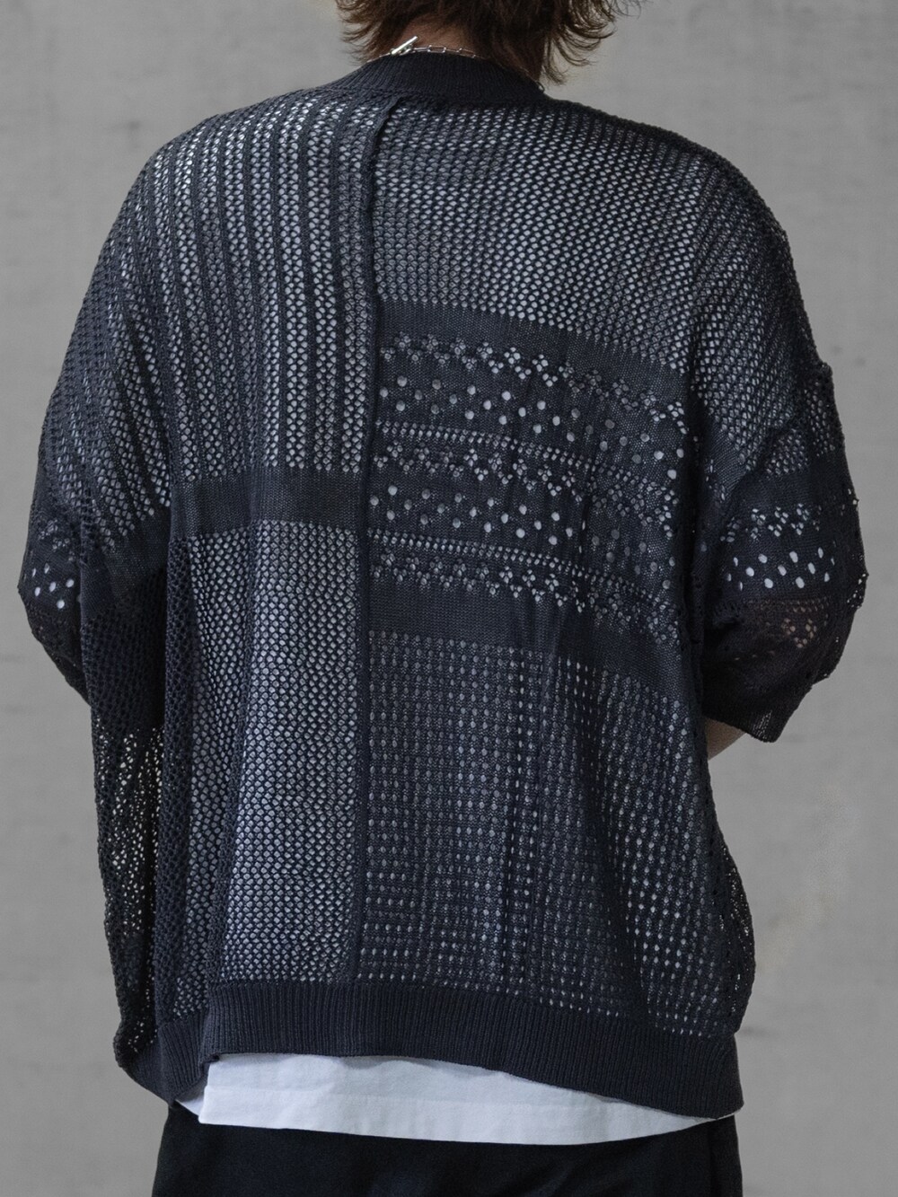 ブラック系のデニムパンツ、ブラック系のドレスシューズ、グレー系のニット/セーターを着用したメンズの春コーディネートの4枚目の写真