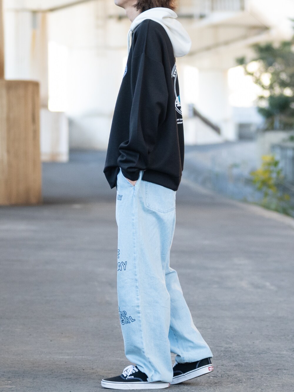ブラック系のパーカー、ブルー系のデニムパンツ、ブラック系のスニーカーを着用したメンズの冬コーディネートの2枚目の写真