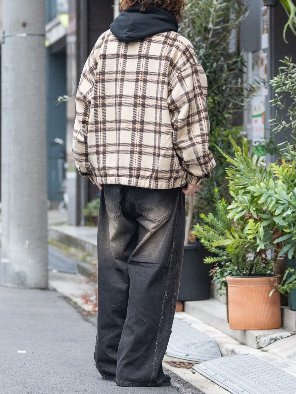 ブラウン系のブルゾン、ブラウン系のデニムパンツ、ブラック系のパーカーを着用したメンズの冬コーディネートの3枚目の写真