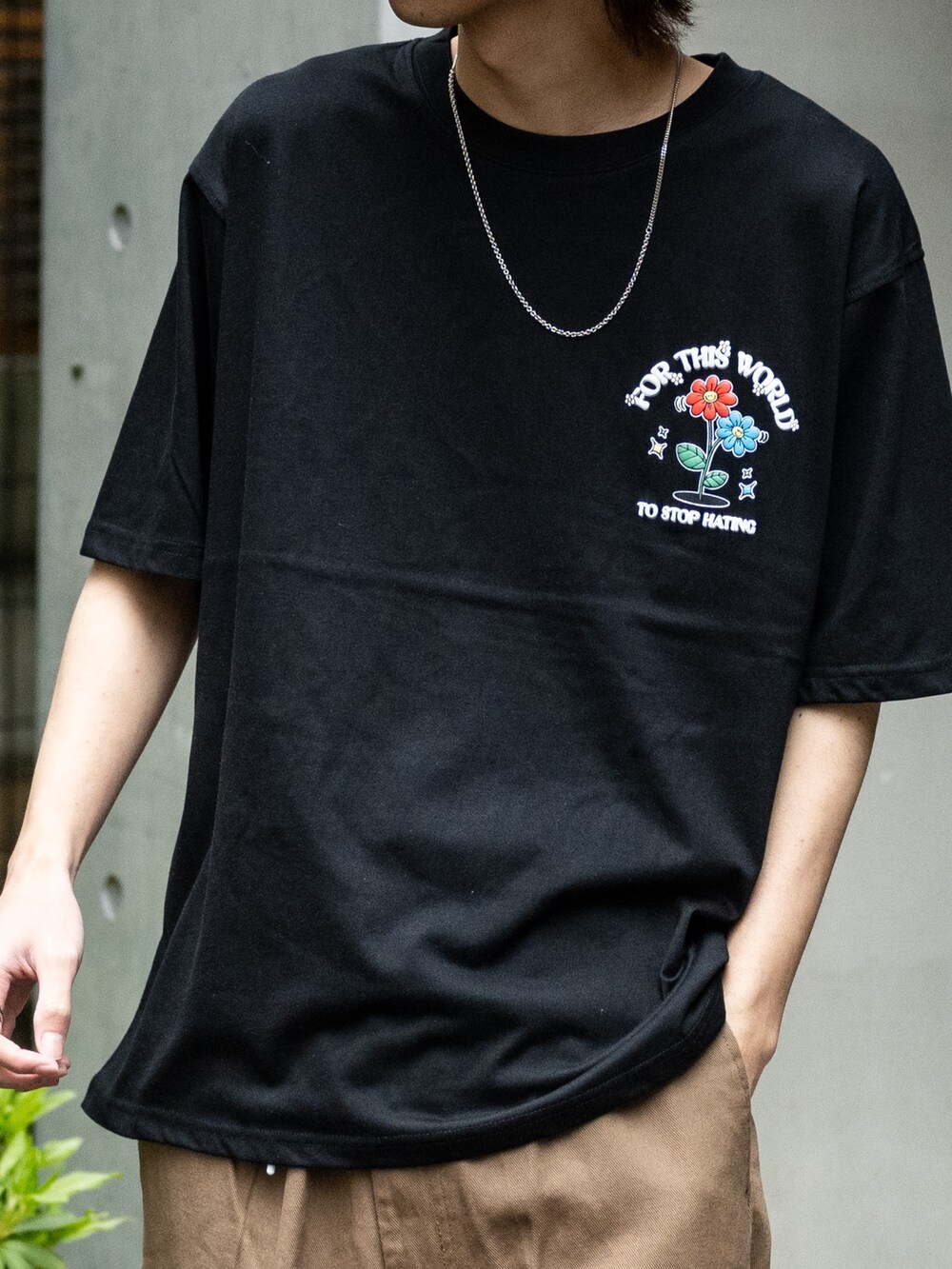 ブラウン系のデニムパンツ、ブラック系のスニーカー、ブラック系のTシャツ/カットソーを着用したメンズの春コーディネートの3枚目の写真