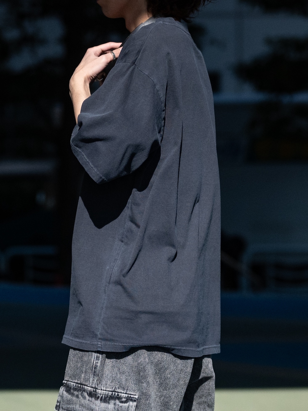 ブラック系のカーゴパンツ、ホワイト系のスニーカー、ブラック系のTシャツ/カットソーを着用したメンズの春コーディネートの3枚目の写真