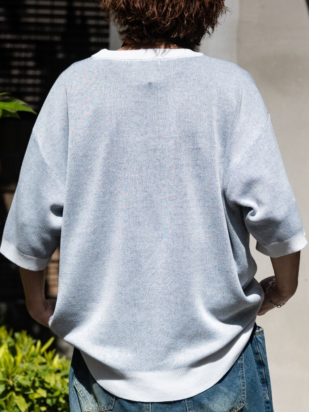 ブルー系のデニムパンツ、ホワイト系のスニーカー、ホワイト系のニット/セーターを着用したメンズの春コーディネートの3枚目の写真