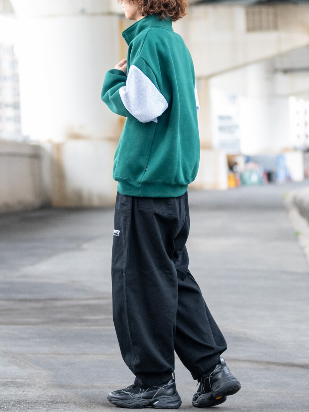 ブラック系のデニムパンツ、グリーン系のスウェットを着用したメンズの秋コーディネートの2枚目の写真