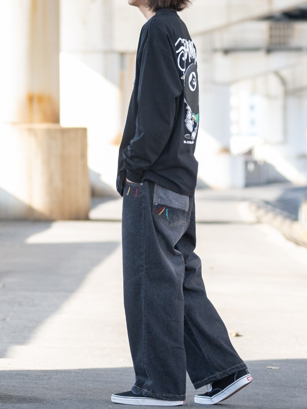 ブラック系のスニーカー、ブルー系のデニムパンツ、ブラック系のTシャツ/カットソーを着用したメンズの春コーディネートの2枚目の写真