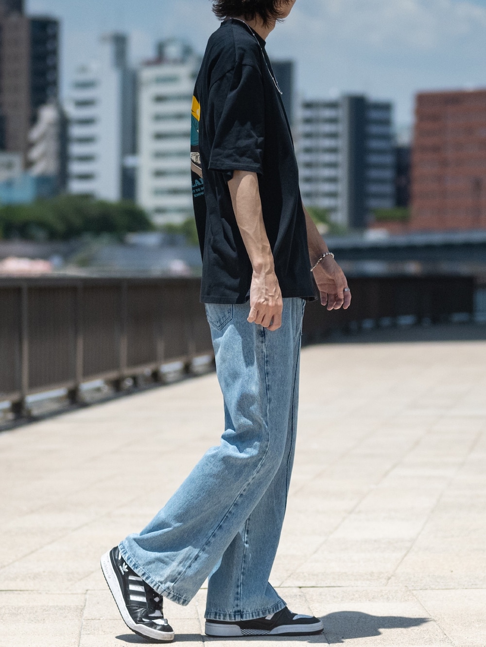 ブルー系のデニムパンツ、ブラック系のTシャツ/カットソーを着用したメンズの夏コーディネートの2枚目の写真