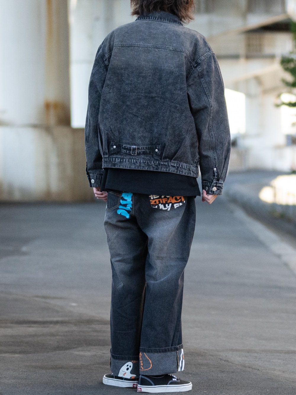 ブラック系のスニーカー、ブルー系のデニムパンツ、ブラック系のTシャツ/カットソーを着用したメンズの春コーディネートの3枚目の写真