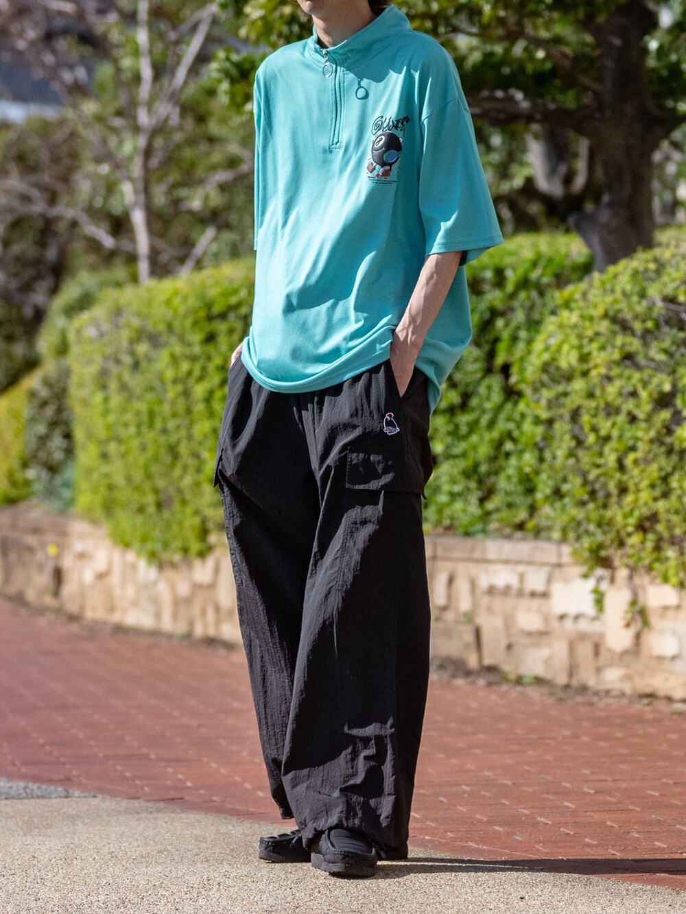 ベージュ系のカーゴパンツ、グリーン系のTシャツ/カットソーを着用したメンズの春コーディネートの2枚目の写真
