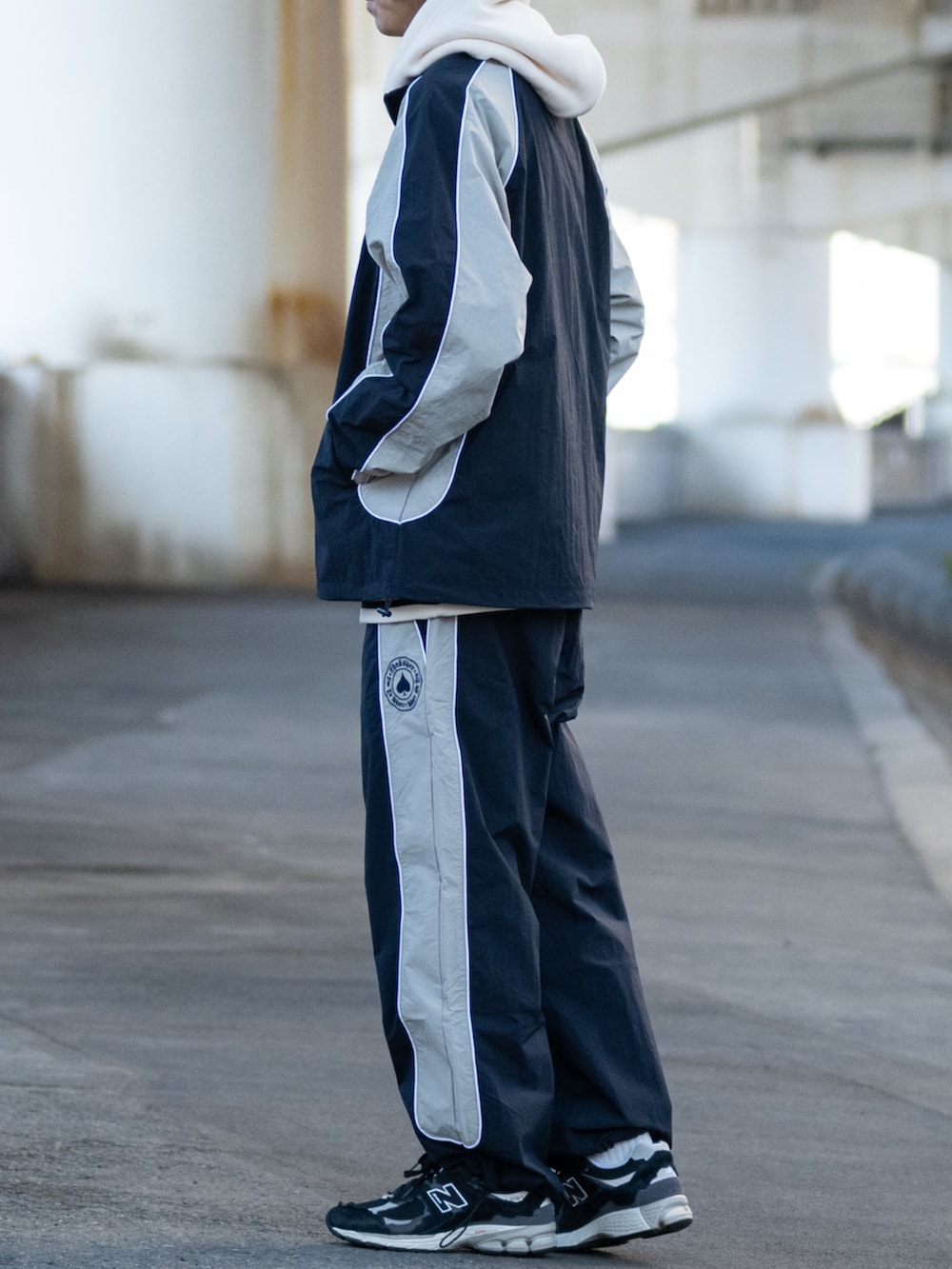 ブラック系のスニーカー、ホワイト系のパーカー、グレー系のその他パンツを着用したメンズの冬コーディネートの2枚目の写真