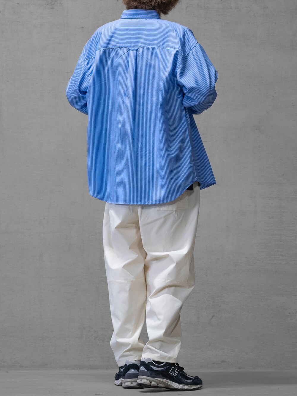 ブラック系のスニーカー、ホワイト系のスラックス、ブルー系のシャツ/ブラウスを着用したメンズの春コーディネートの3枚目の写真