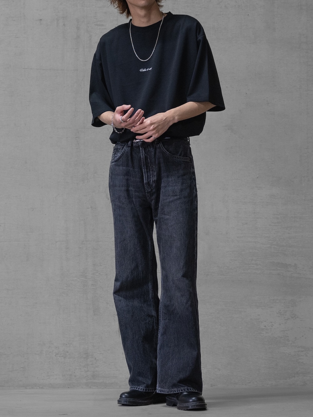 ブラック系のデニムパンツ、ブラック系のドレスシューズ、ブラック系のTシャツ/カットソーを着用したメンズの春コーディネートの2枚目の写真