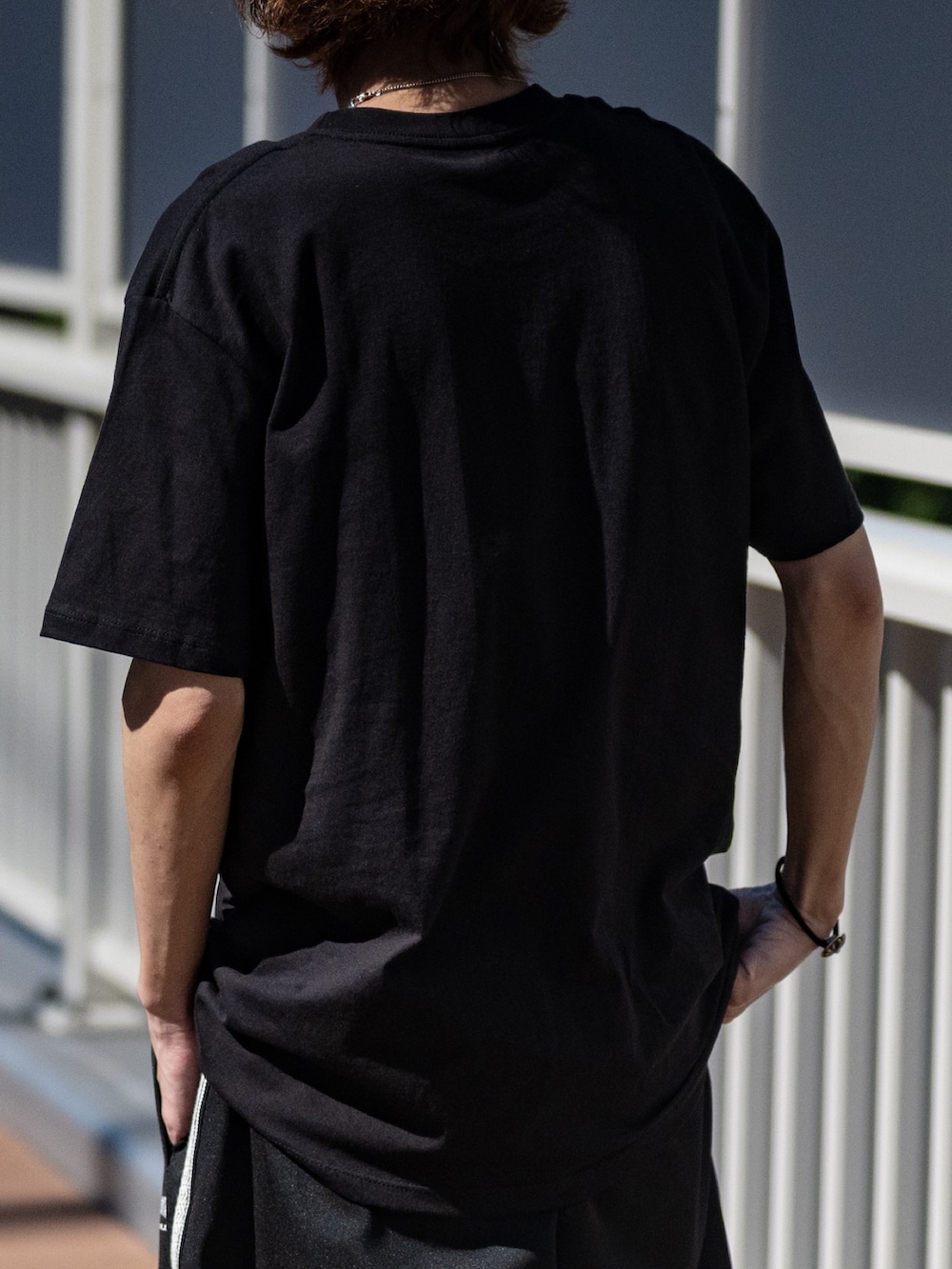 ブラック系のジャージ、ブラック系のTシャツ/カットソーを着用したメンズの夏コーディネートの4枚目の写真