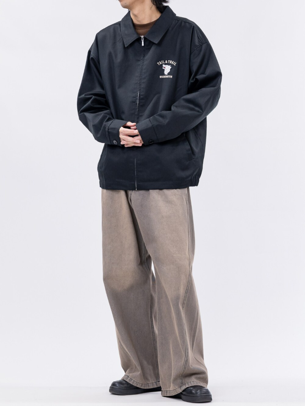 ブラック系のスニーカー、ブラック系のブルゾン、ブラウン系のデニムパンツを着用したメンズの秋コーディネートの3枚目の写真