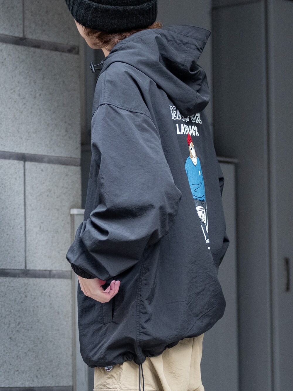 ベージュ系のカーゴパンツ、ブラック系のナイロンジャケットを着用したメンズの春コーディネートの4枚目の写真