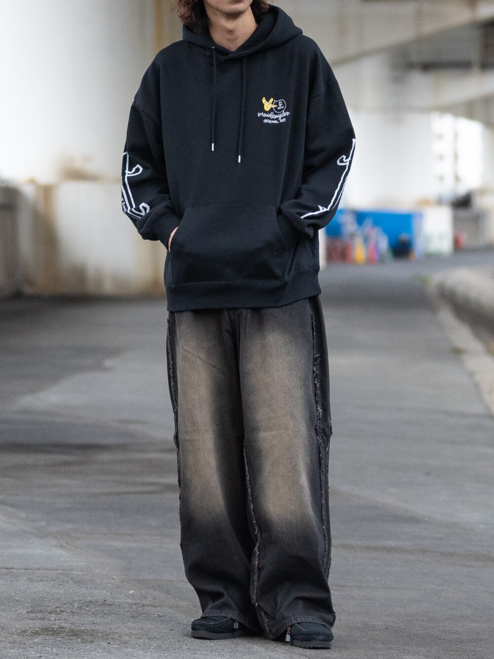 ブラウン系のデニムパンツ、ブラック系のパーカーを着用したメンズの冬コーディネートの3枚目の写真