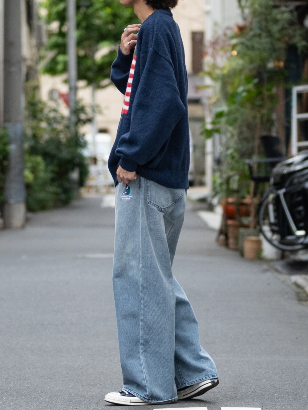 ブラック系のスニーカー、ブルー系のデニムパンツ、ブルー系のニット/セーターを着用したメンズの冬コーディネートの2枚目の写真