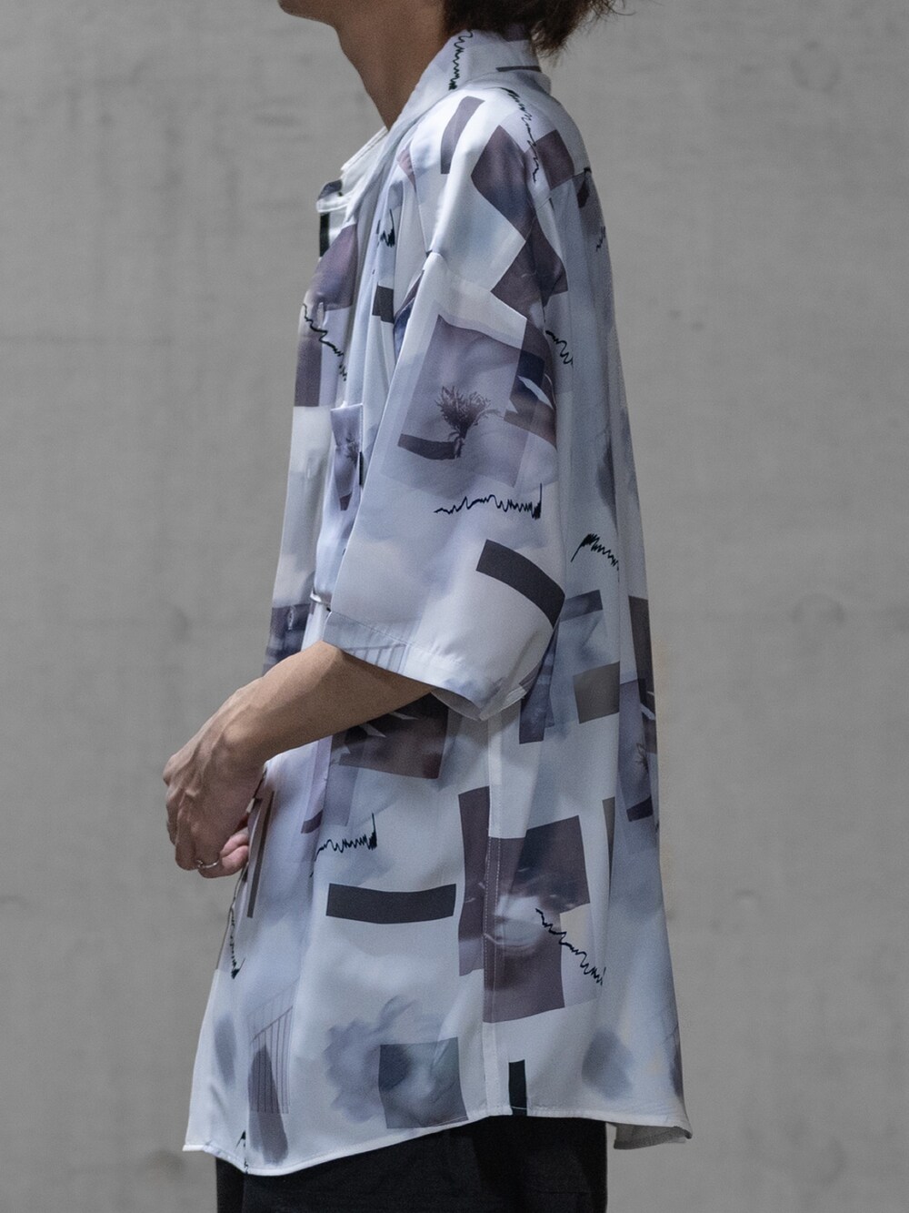 グレー系のスラックス、ブラック系のドレスシューズ、ホワイト系のシャツ/ブラウスを着用したメンズの春コーディネートの3枚目の写真