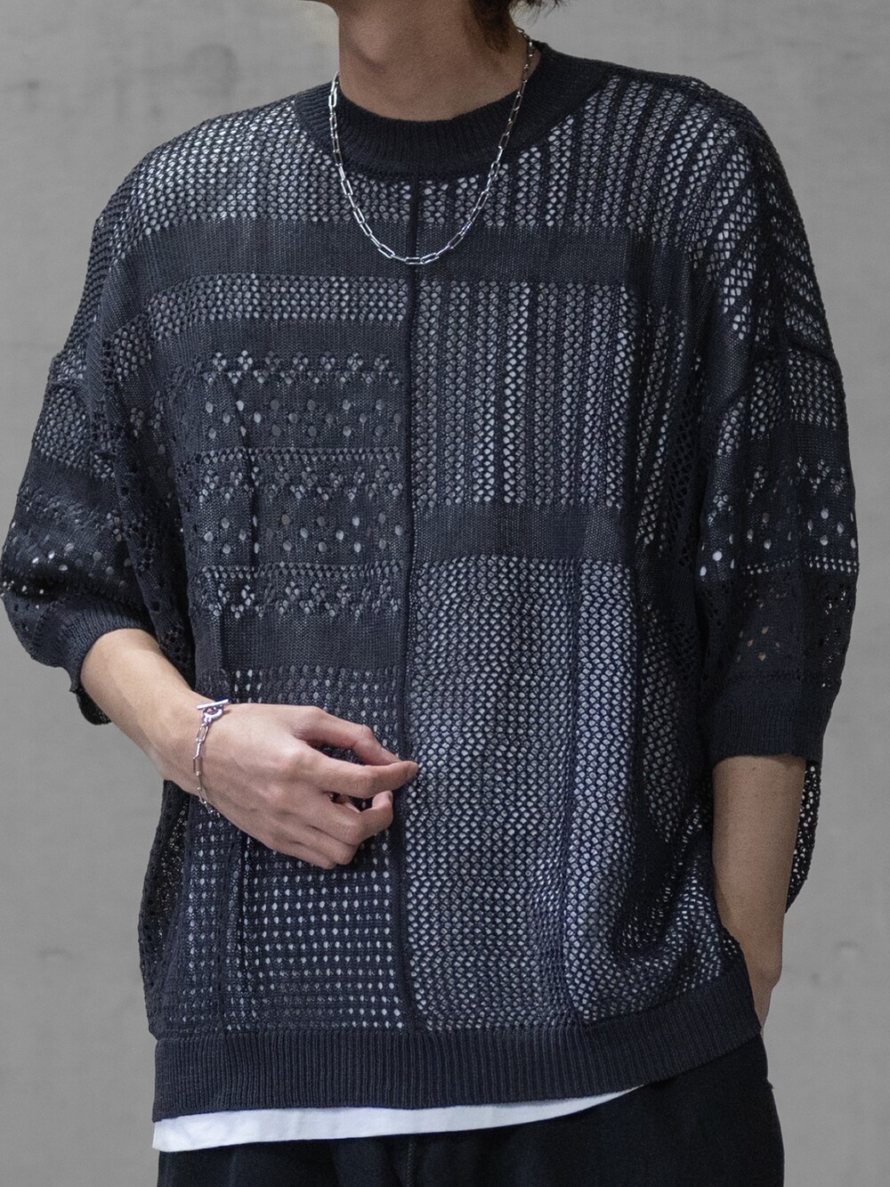 ブラック系のデニムパンツ、ブラック系のドレスシューズ、グレー系のニット/セーターを着用したメンズの春コーディネートの2枚目の写真