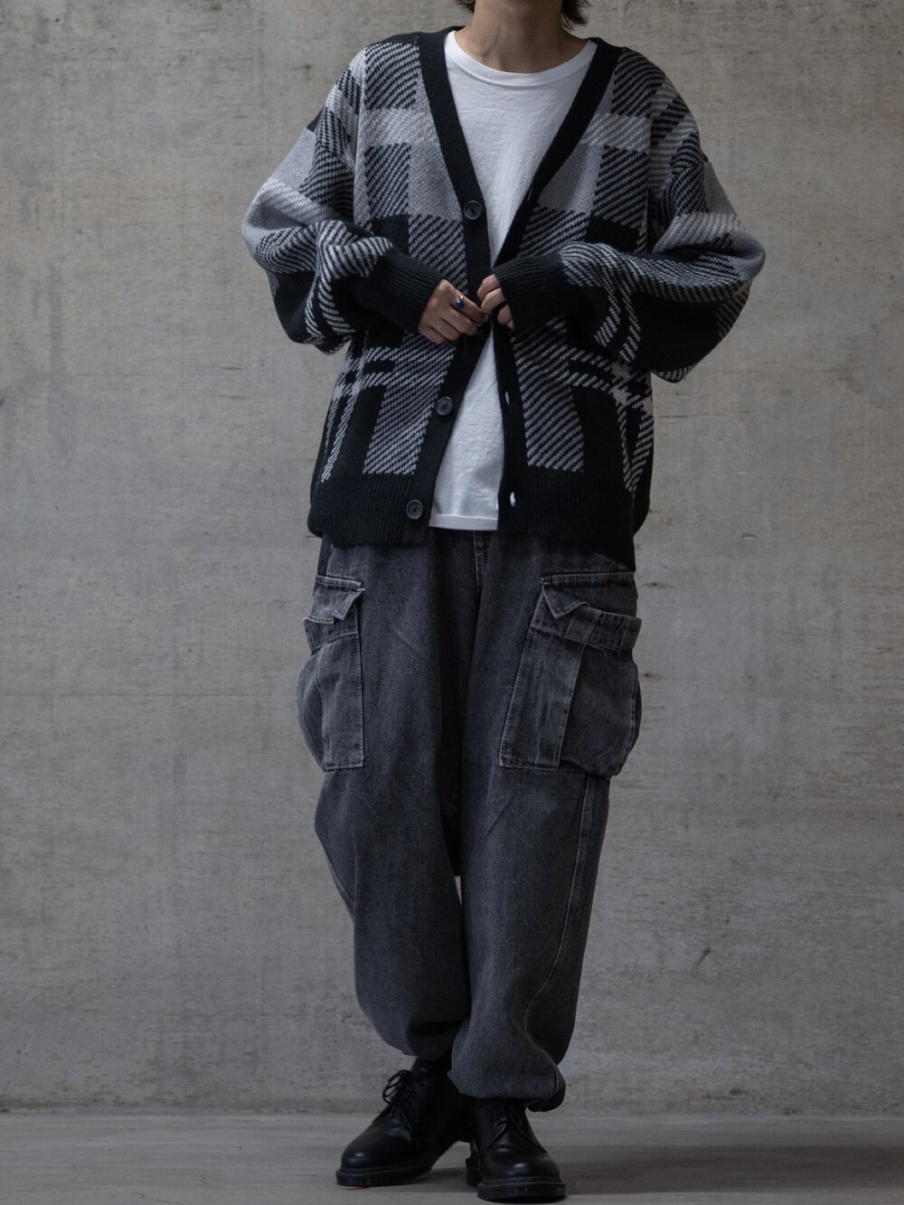 ブラック系のデニムパンツ、ブラック系のブーツ、ブラック系のカーディガン/ボレロを着用したメンズの秋コーディネートの2枚目の写真