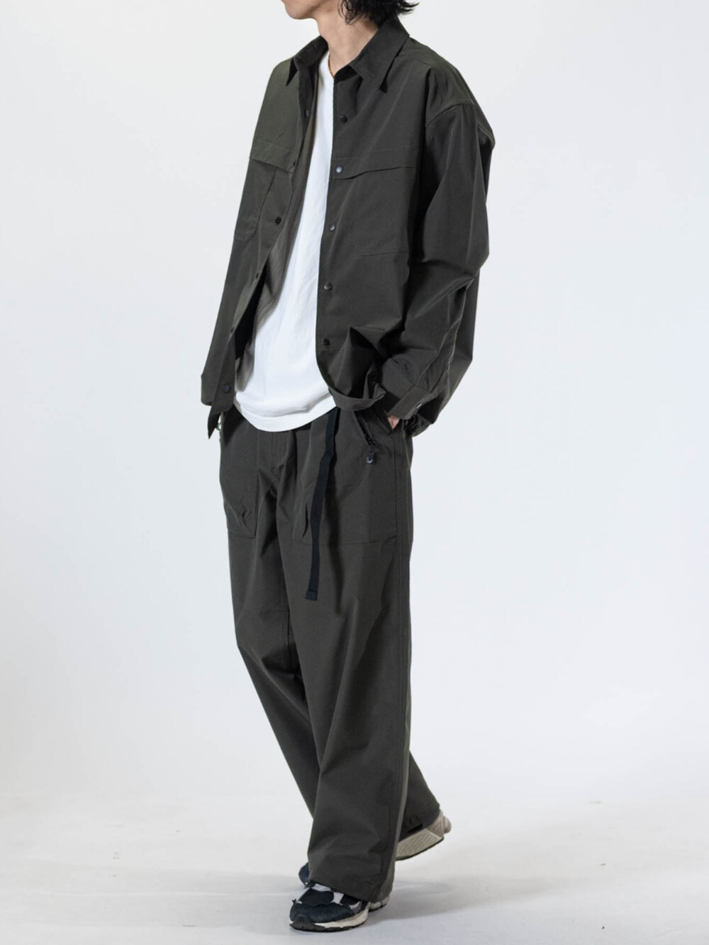 ブラック系のスニーカー、グリーン系のチノパンツ、グリーン系のシャツ/ブラウスを着用したメンズの夏コーディネートの2枚目の写真