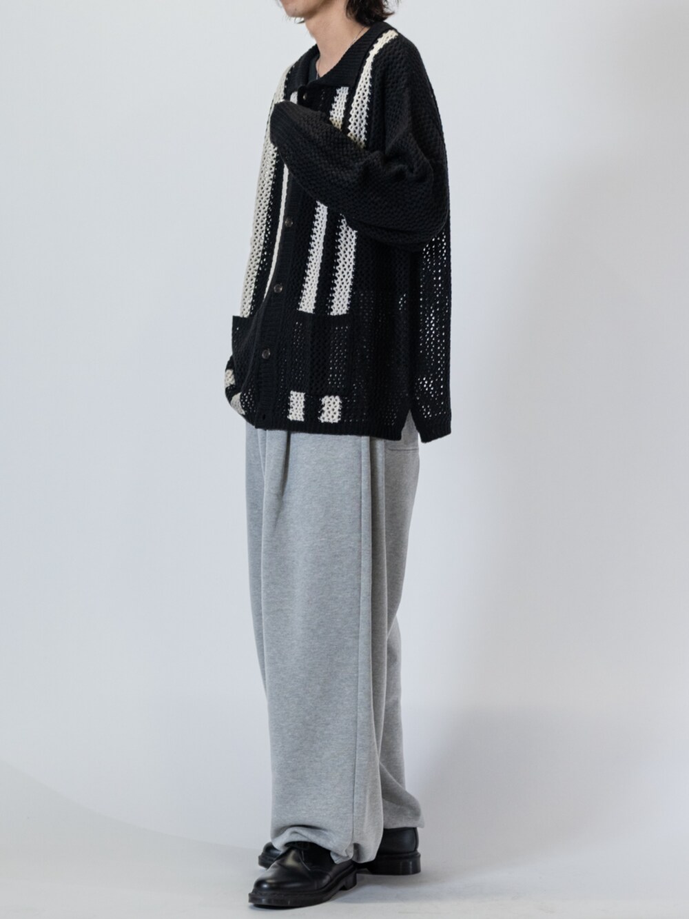 ブラック系のドレスシューズ、ブラック系のカーディガン/ボレロ、グレー系のスウェットパンツを着用したメンズの春コーディネートの2枚目の写真