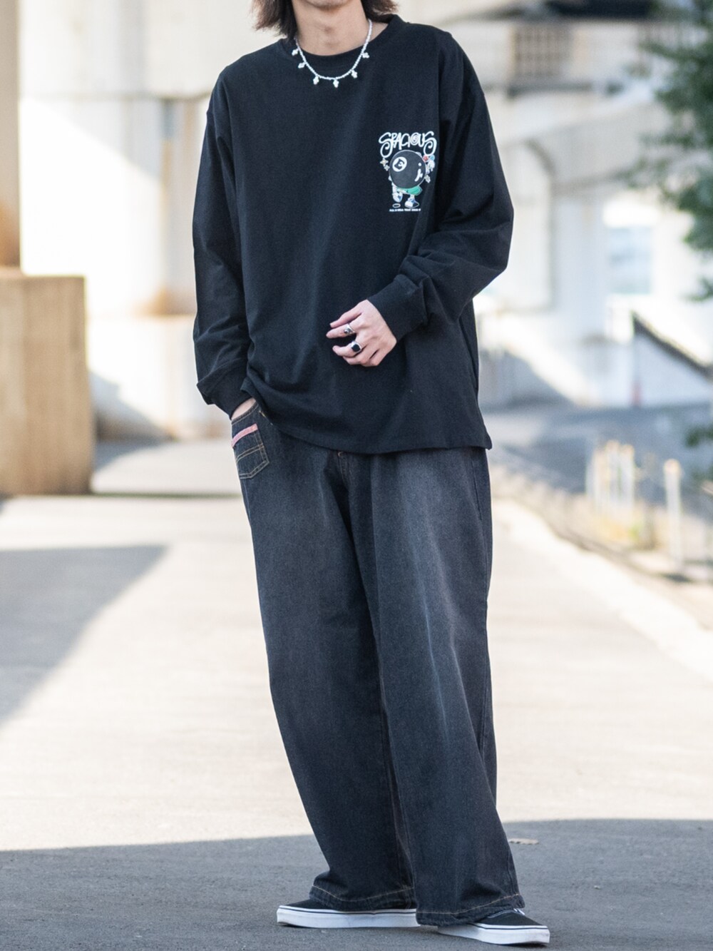 ブラック系のスニーカー、ブルー系のデニムパンツ、ブラック系のTシャツ/カットソーを着用したメンズの春コーディネートの3枚目の写真