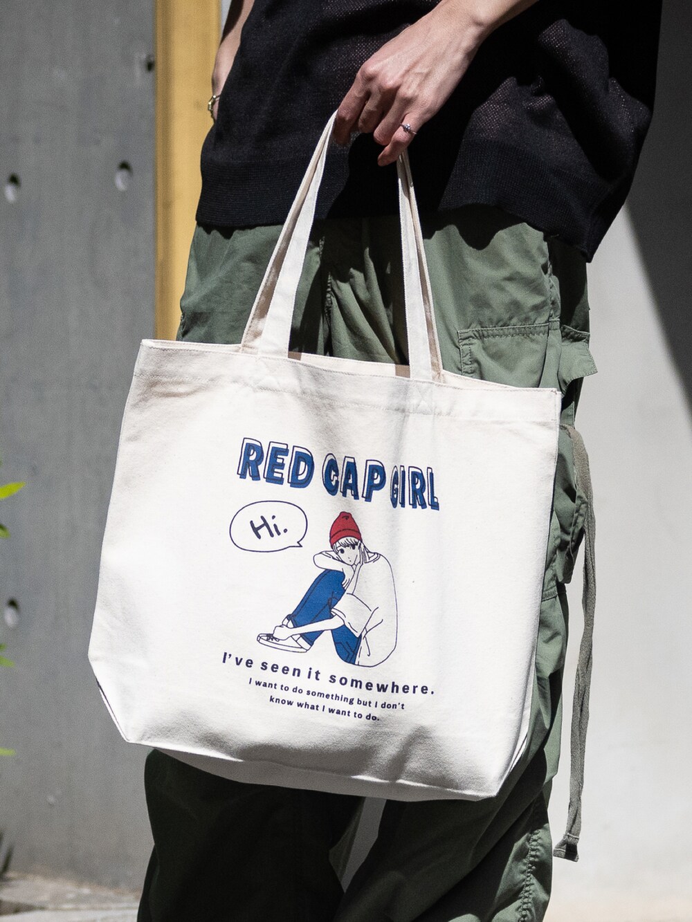 ホワイト系のスニーカー、ブルー系のトートバッグ、ブラック系のニット/セーターを着用したメンズの春コーディネートの2枚目の写真