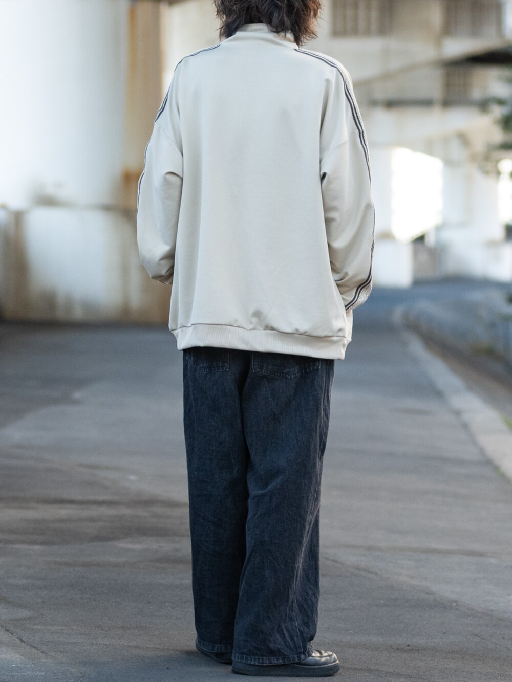 ブラック系のスニーカー、ベージュ系のジャージを着用したメンズの春コーディネートの3枚目の写真