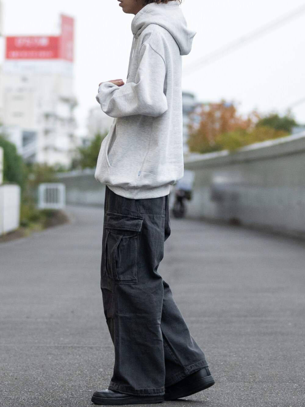 ブラック系のデニムパンツ、グレー系のパーカーを着用したメンズの冬コーディネートの2枚目の写真
