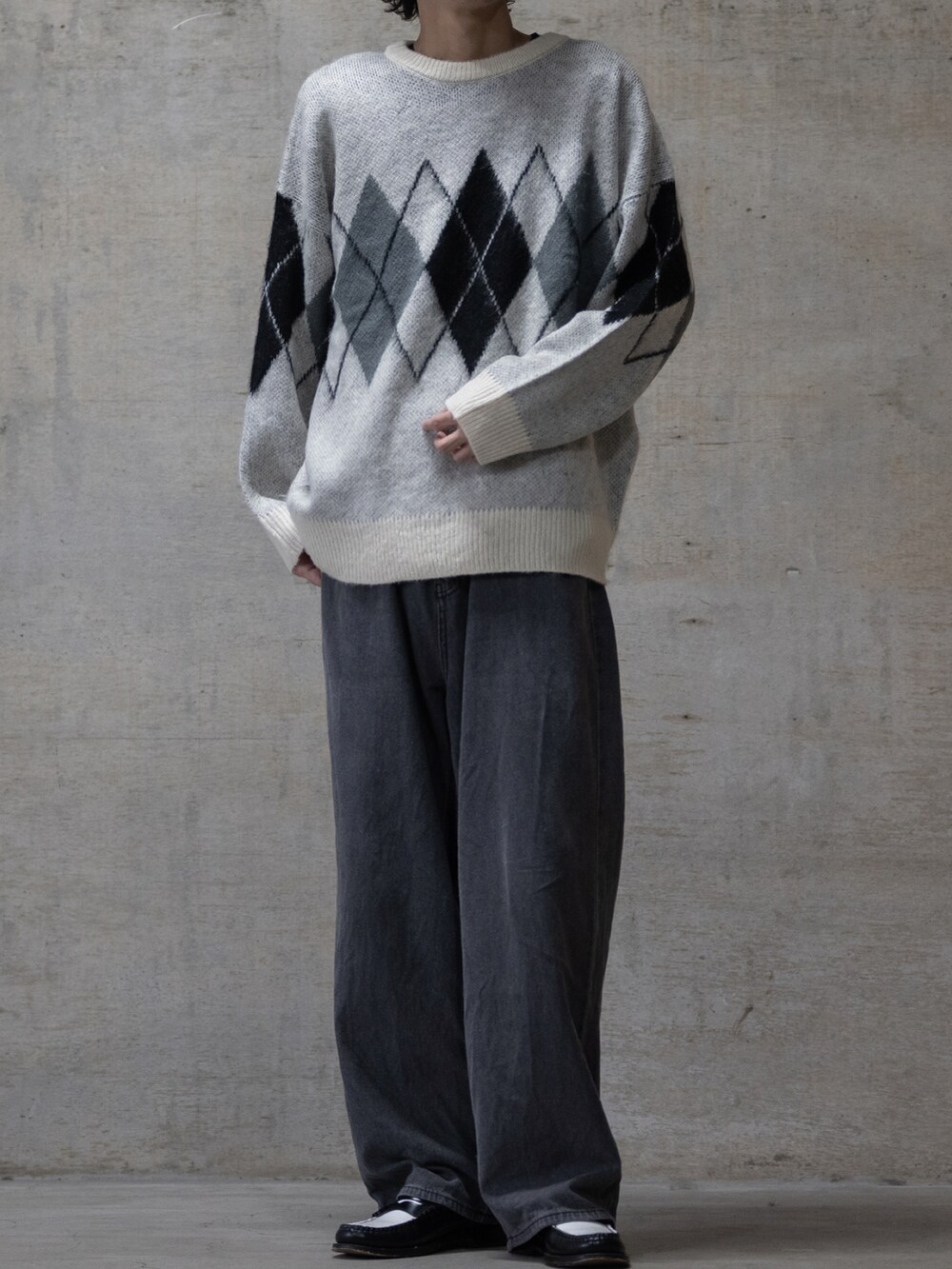 ブラック系のローファー、ホワイト系のニット/セーターを着用したメンズの冬コーディネートの2枚目の写真