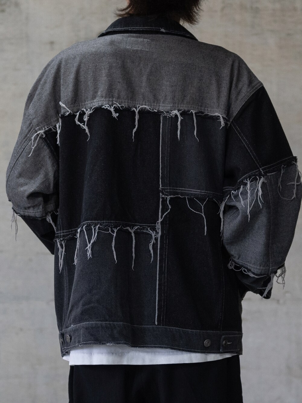 ブラック系のデニムパンツ、ブラック系のデニムジャケット、ブラック系のスニーカーを着用したメンズの冬コーディネートの4枚目の写真