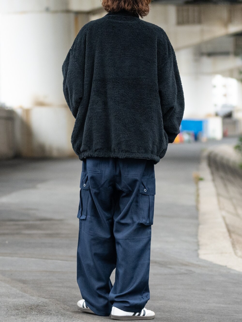 ホワイト系のスニーカー、ブラック系のカーゴパンツ、グレー系のナイロンジャケットを着用したメンズの冬コーディネートの4枚目の写真