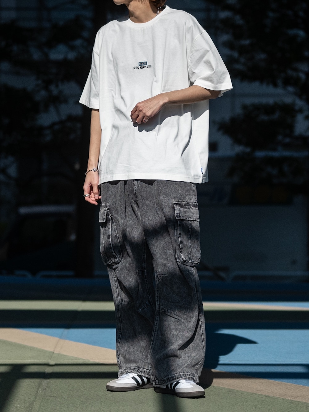 ブラック系のカーゴパンツ、ホワイト系のスニーカー、ホワイト系のTシャツ/カットソーを着用したメンズの春コーディネートの2枚目の写真