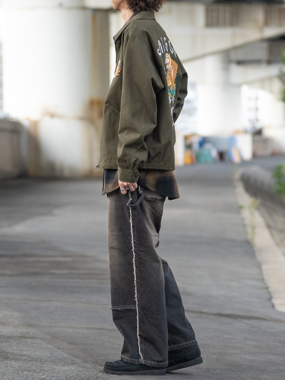 ブラック系のシャツ/ブラウス、グリーン系のミリタリージャケット、ブラック系のデニムパンツを着用したメンズの秋コーディネートの2枚目の写真