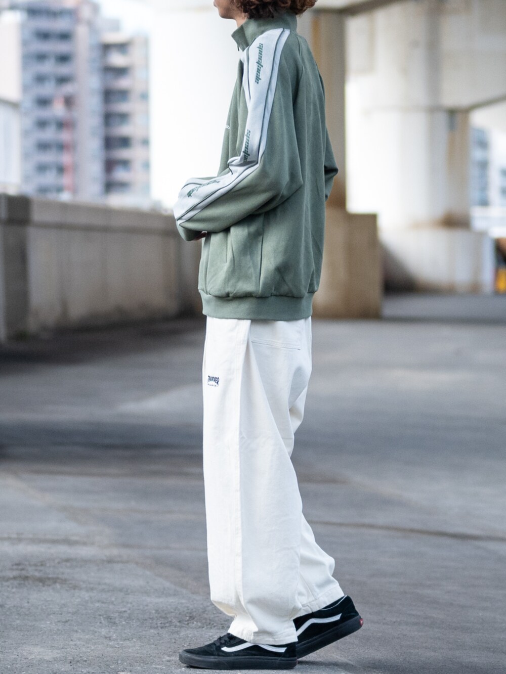 ホワイト系のデニムパンツ、グリーン系のジャージを着用したメンズの秋コーディネートの2枚目の写真