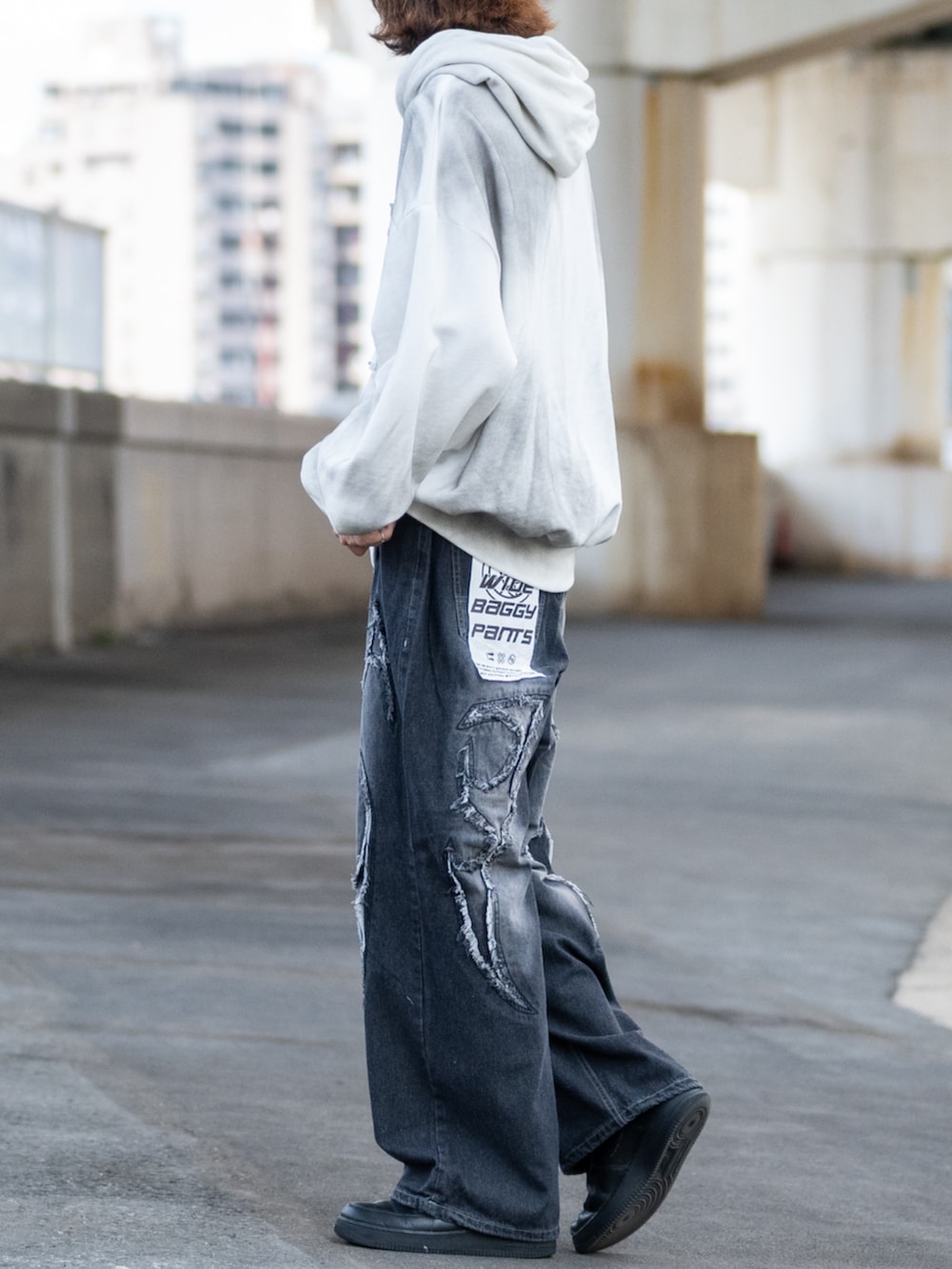 ホワイト系のパーカー、ブラック系のデニムパンツを着用したメンズの秋コーディネートの2枚目の写真