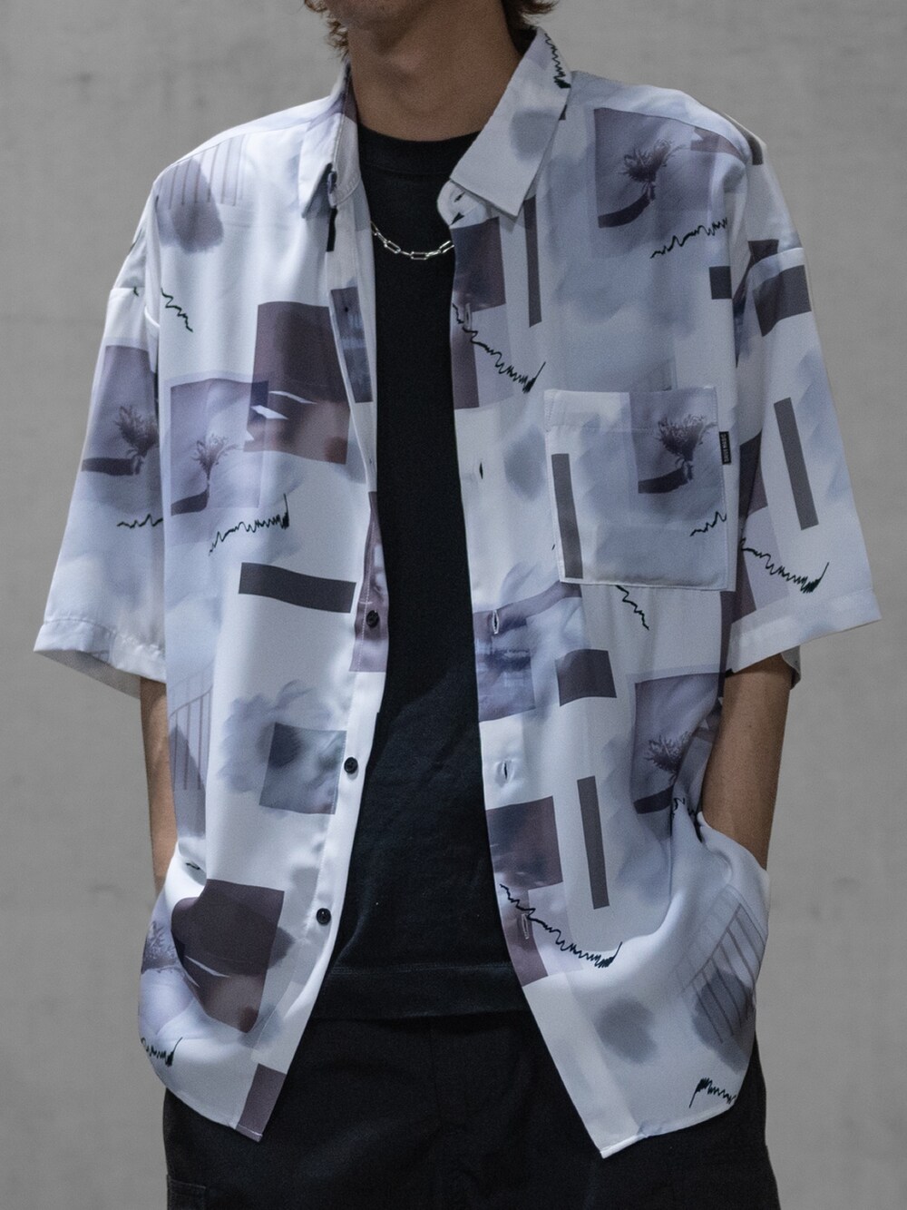 グレー系のスラックス、ブラック系のドレスシューズ、ホワイト系のシャツ/ブラウスを着用したメンズの春コーディネートの2枚目の写真