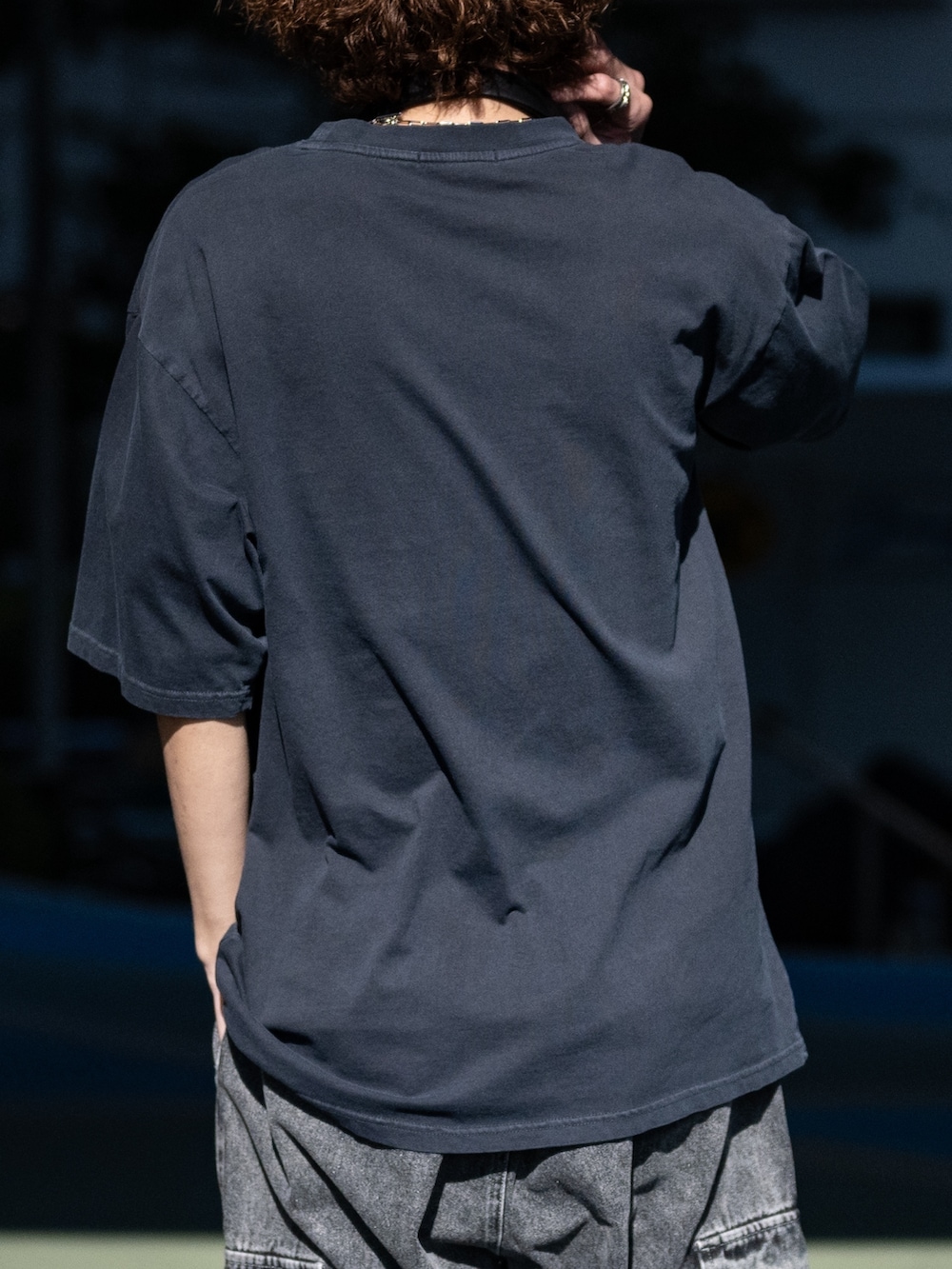 ブラック系のカーゴパンツ、ホワイト系のスニーカー、ブラック系のTシャツ/カットソーを着用したメンズの春コーディネートの4枚目の写真