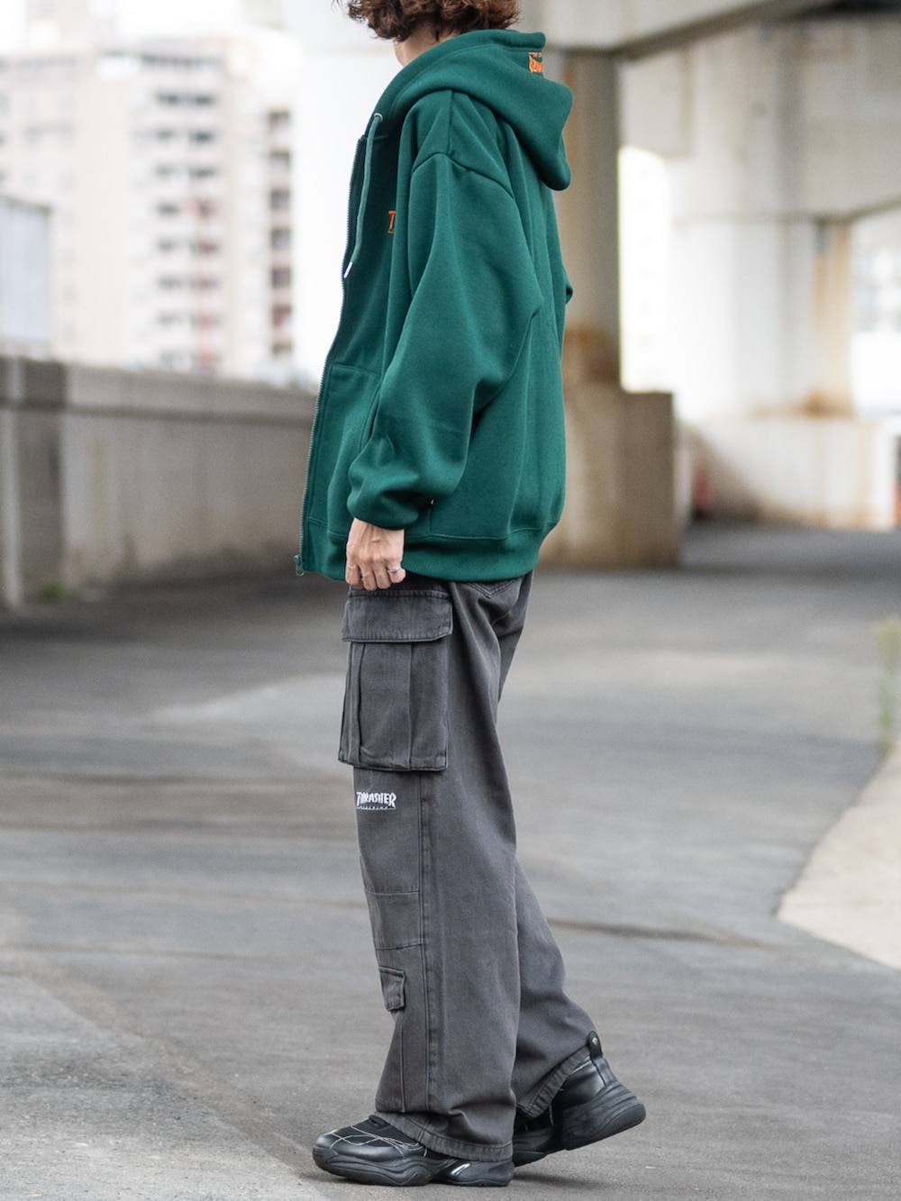 ブラック系のデニムパンツ、グリーン系のパーカーを着用したメンズの秋コーディネートの2枚目の写真