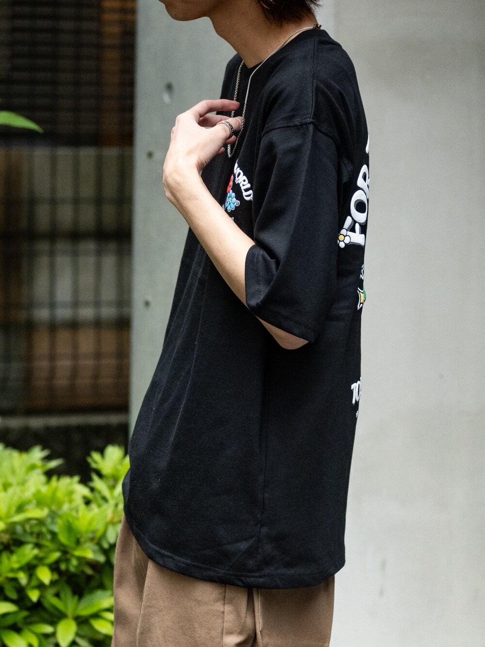 ブラウン系のデニムパンツ、ブラック系のスニーカー、ブラック系のTシャツ/カットソーを着用したメンズの春コーディネートの4枚目の写真