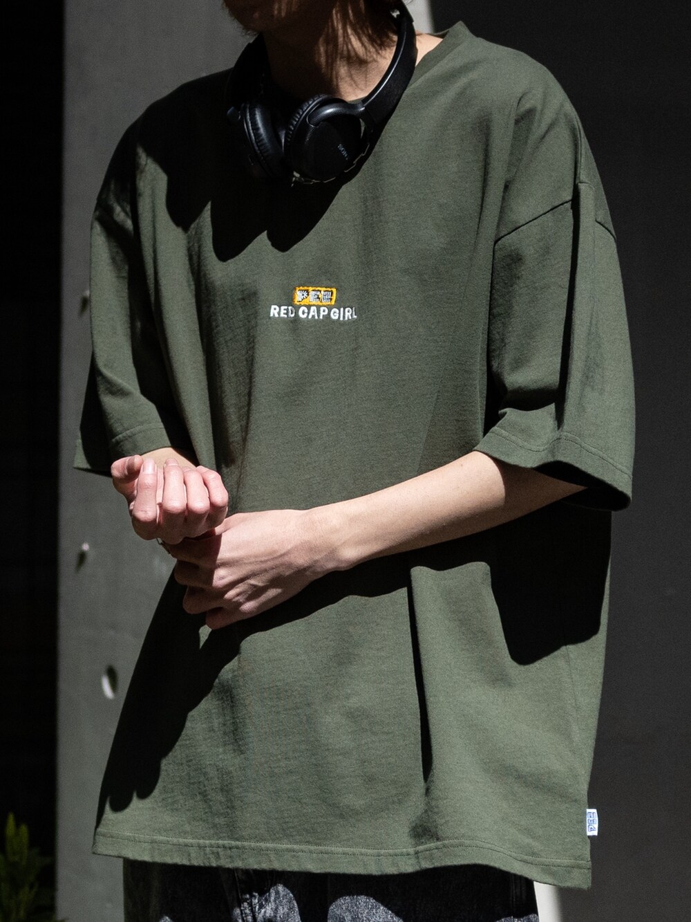 ブラック系のカーゴパンツ、グリーン系のTシャツ/カットソー、ブラック系のスニーカーを着用したメンズの春コーディネートの5枚目の写真