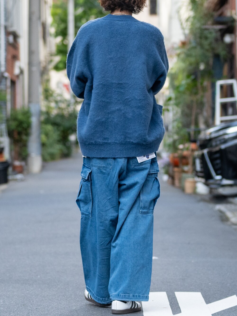ホワイト系のスニーカー、ブルー系のデニムパンツ、ブルー系のカーディガン/ボレロを着用したメンズの冬コーディネートの3枚目の写真
