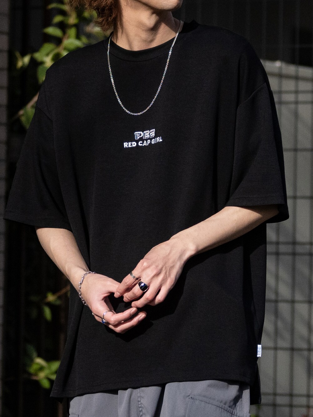 グレー系のカーゴパンツ、ホワイト系のスニーカー、ブラック系のTシャツ/カットソーを着用したメンズの春コーディネートの3枚目の写真