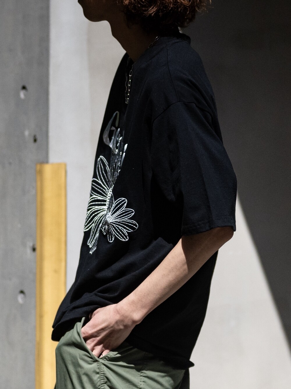 ホワイト系のスニーカー、ブラック系のTシャツ/カットソー、その他のネックレスを着用したメンズの春コーディネートの3枚目の写真