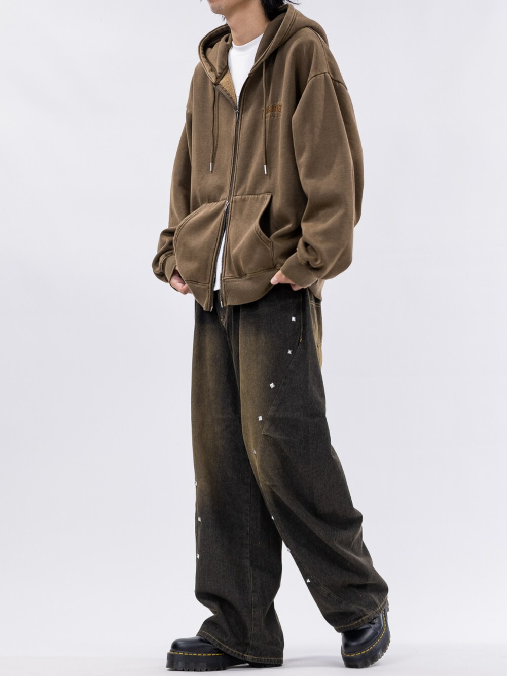 ブラウン系のパーカー、ブラック系のデニムパンツを着用したメンズの秋コーディネートの2枚目の写真